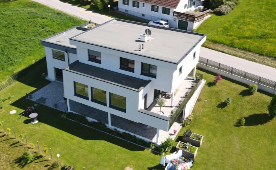 Modernes zweigeschossiges Einfamilienhaus mit Flachdach, weißer Fassade und großer Terrasse